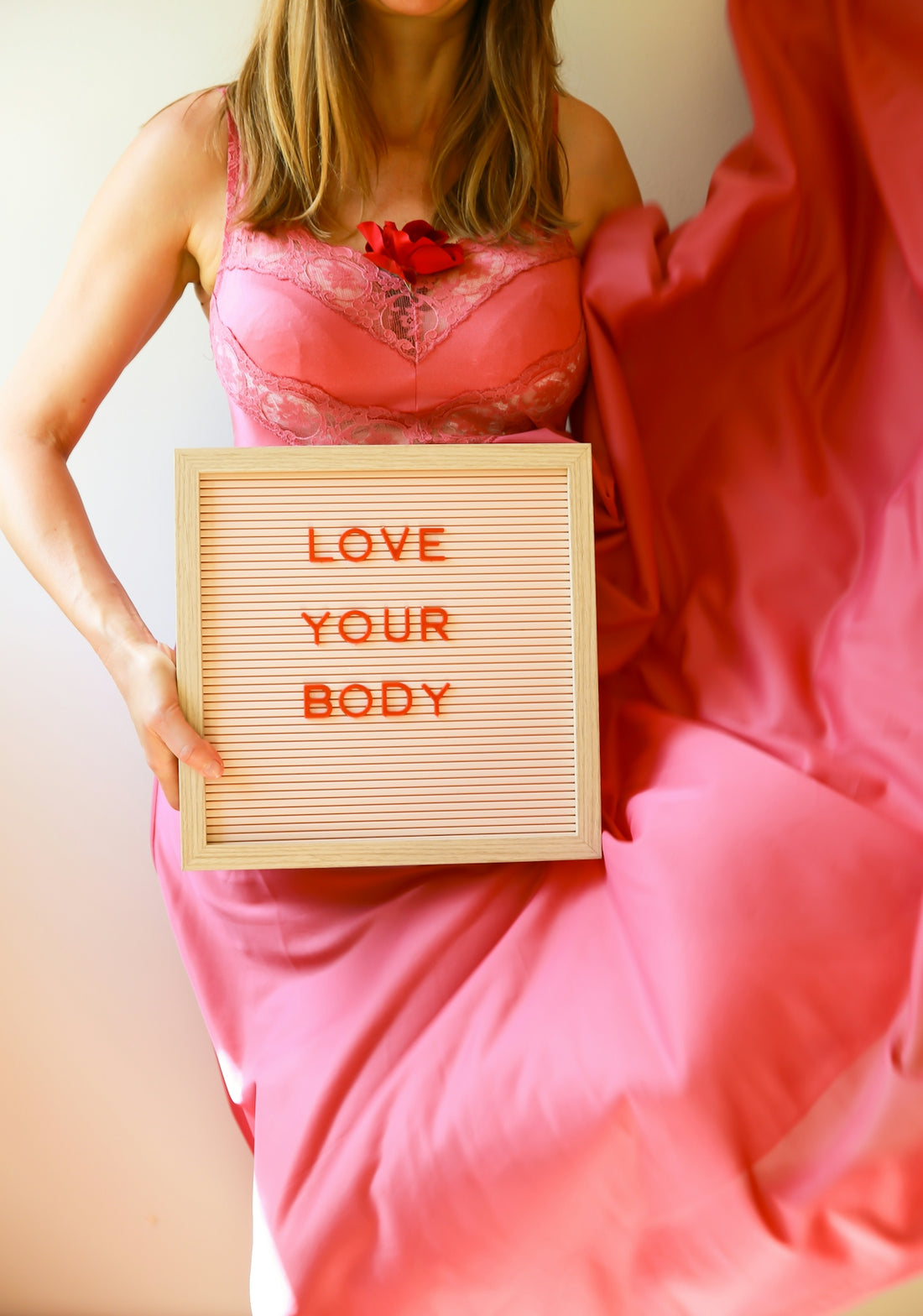 Woman holds a sign urging people to love their bodies.